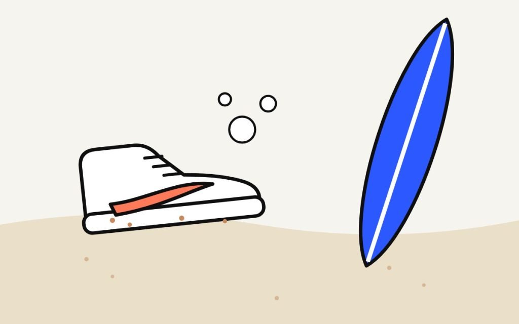 Sandy sneaker next to a surfboard on the beach